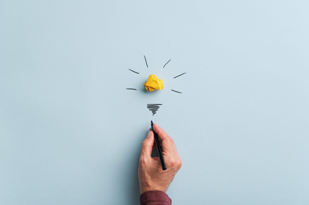 Male hand drawing a light bulb