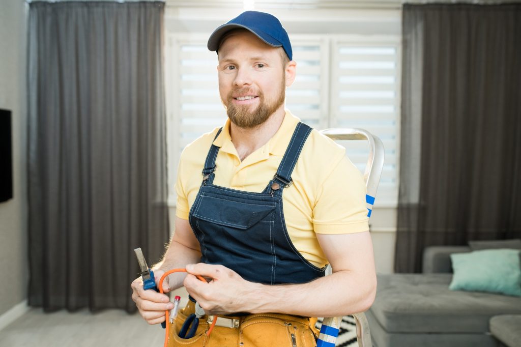 Positive electrician repairing wires in flat